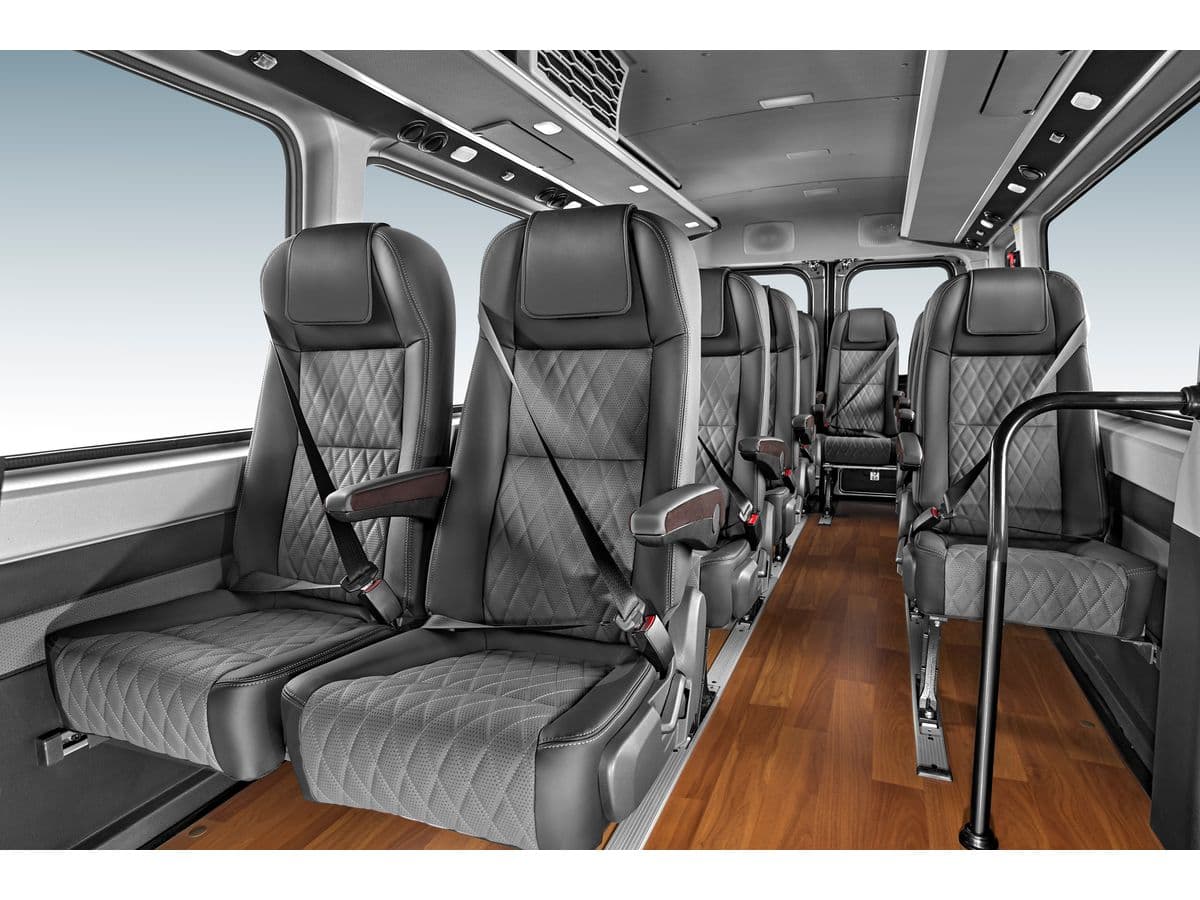 A 16-seater high-roof luxury van at a hotel pickup point