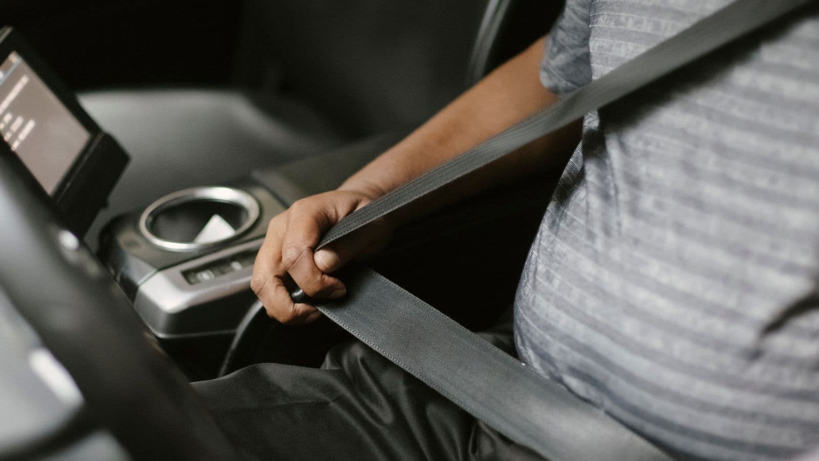 A seatbelt being fastened before a trip — every Amma Tours vehicle is GPS-tracked and AIS-140 compliant
