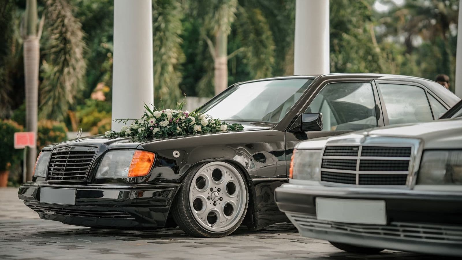 A decorated wedding car waiting at a venue entrance